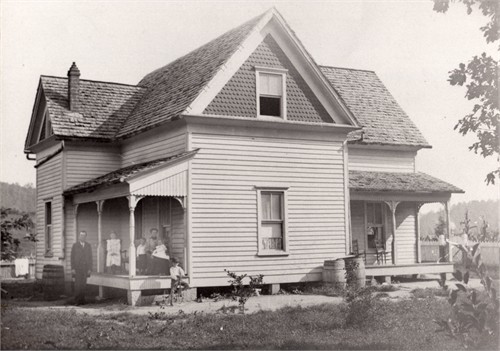 The Stinnette family at their farmhouse in Grainger County, Tennessee (514 KB) Abt 1900 Father Charles Stinnette is standing in the yard, Maude is standing on the porch, brother Frederick is on the bicycle, mother Sally is sitting on the chair holding Flavia on her lap and brother Bolton is standing next to Sally. Photo courtesy of Tina Brannan. (Click on Picture to View Full Size) picture